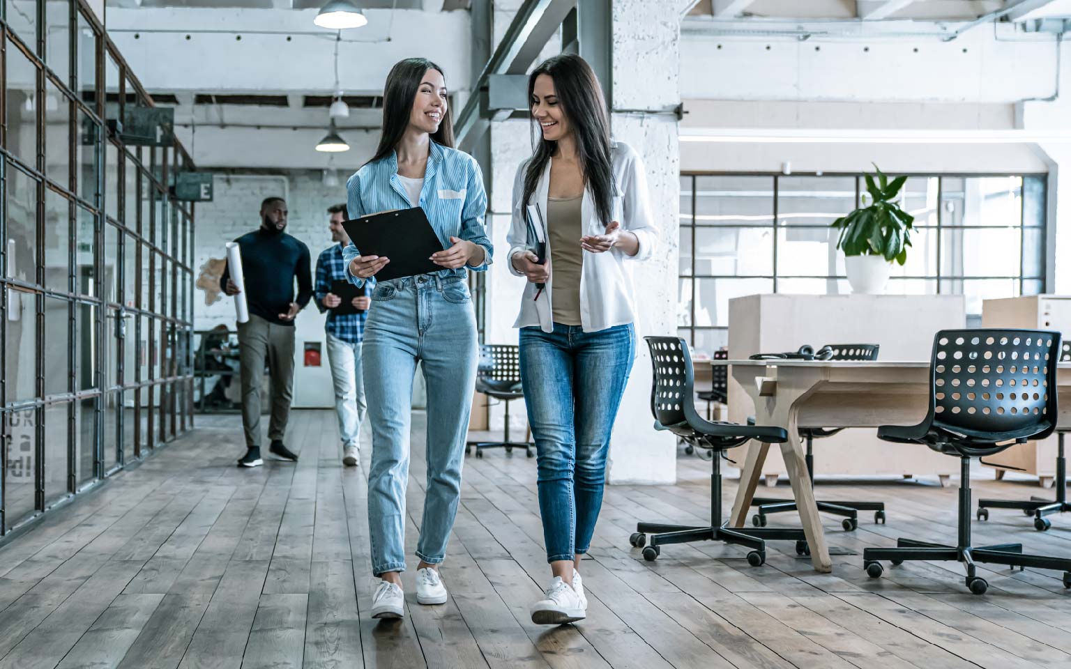 a group of people walking in the office next to each other