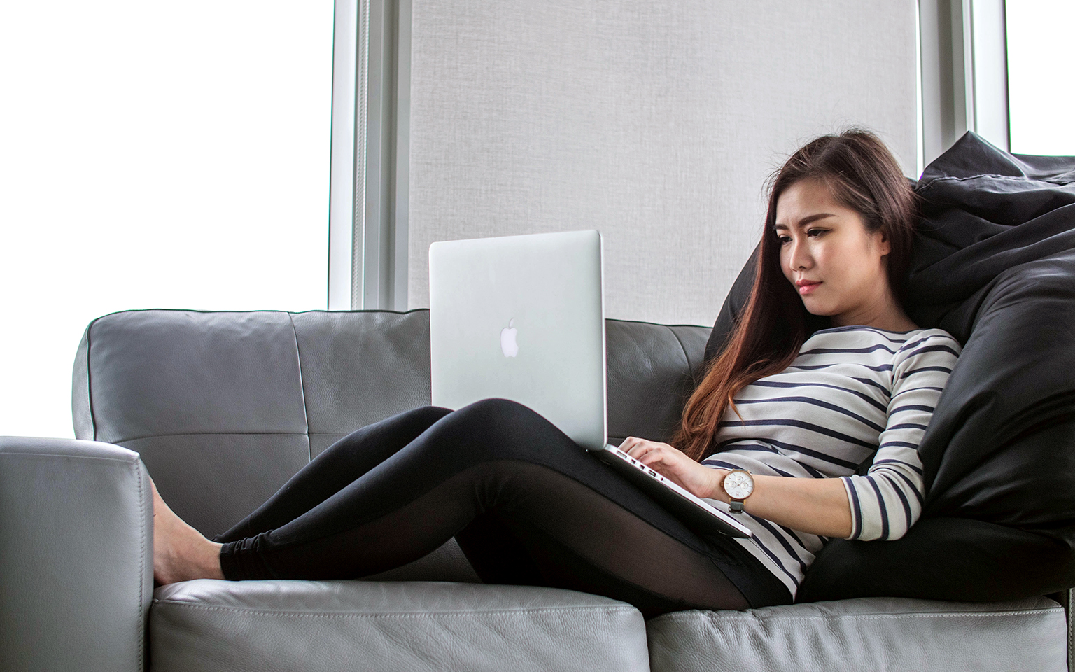 Asia woman working on laptop on couch at home